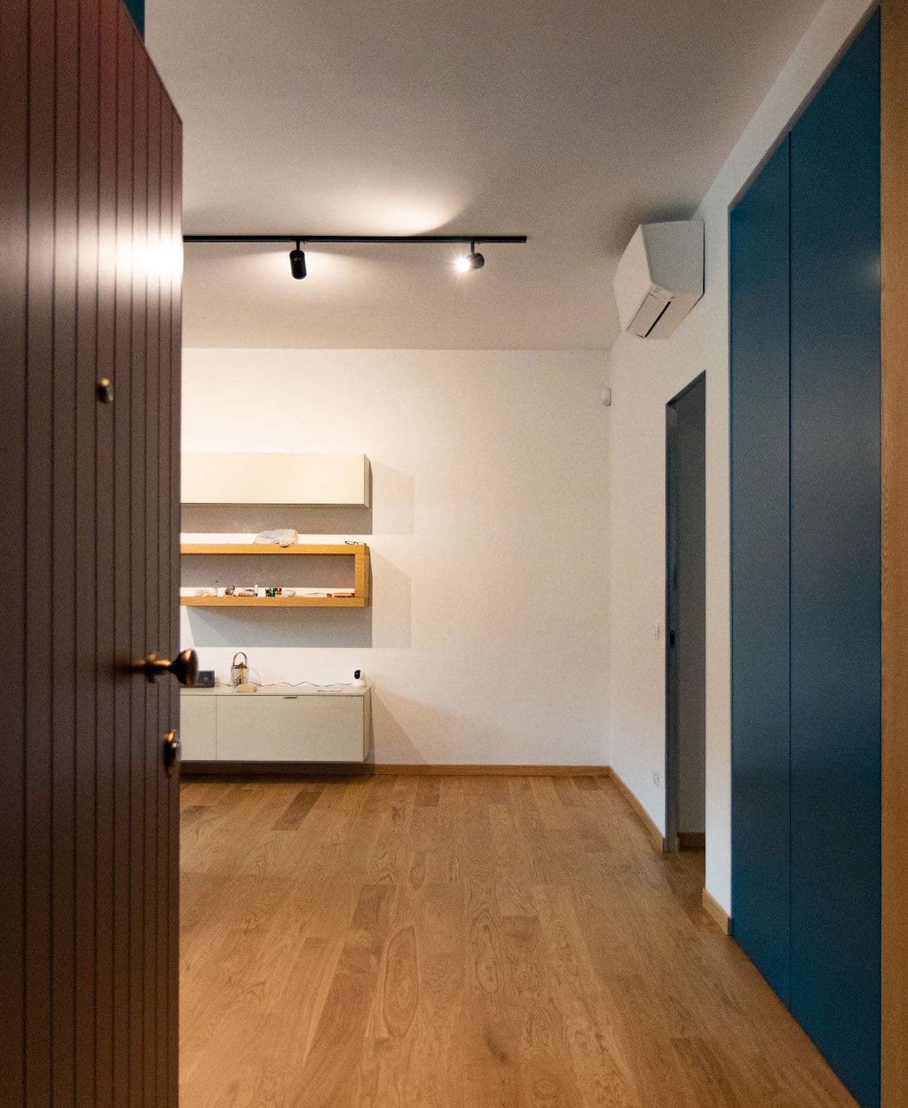 Casa Vito, Ferrara: corridoio con boiserie in legno e pareti blu petrolio